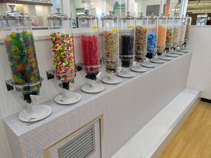 カラフルで様々なディスペンサーがずらりと並ぶ、まねきねこのお菓子バー専用ルームの様子