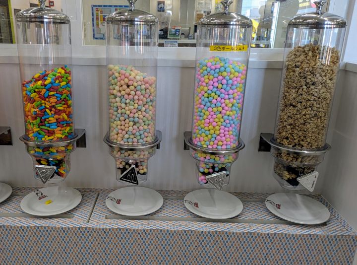 透明なケースにぎっしり詰まった色鮮やかなラムネ、グラノーラなどの各種お菓子