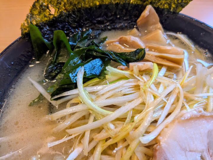 ネギラーメンのトッピングであるたっぷりのネギとわかめのアップ。