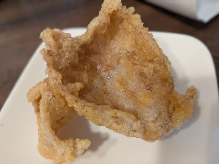なかなかのとなりの鶏皮せんべいの写真。カラッと揚げられた大ぶりの鶏皮。