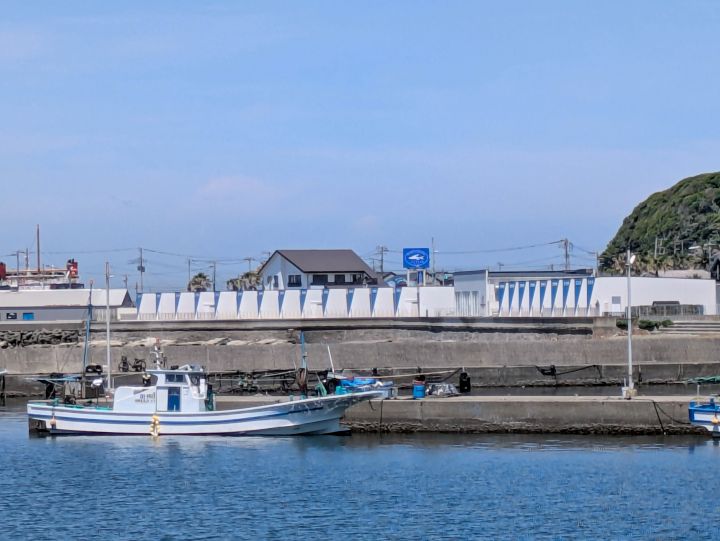 駐車場から見えるザ・フィッシュの看板と海