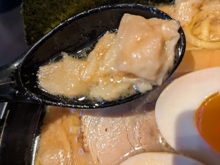 スープに浮かぶ大きめの背脂のアップ