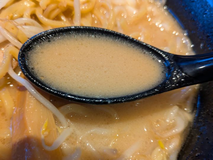 レンゲですくった白濁した味噌スープ