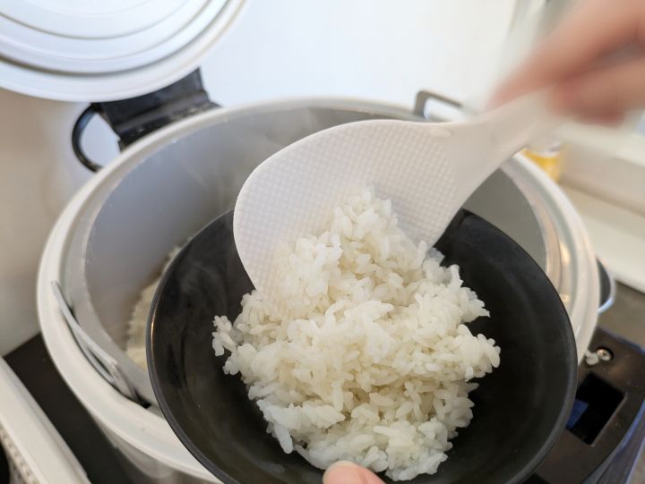 かわみ家の無料ライスをしゃもじでよそう様子