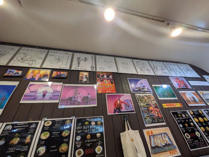 木更津ラーメン大輝の店内壁に飾られたサインとマジックショーの写真